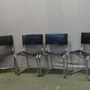 Set of four tubular frame chairs with black saddle leather upholstery